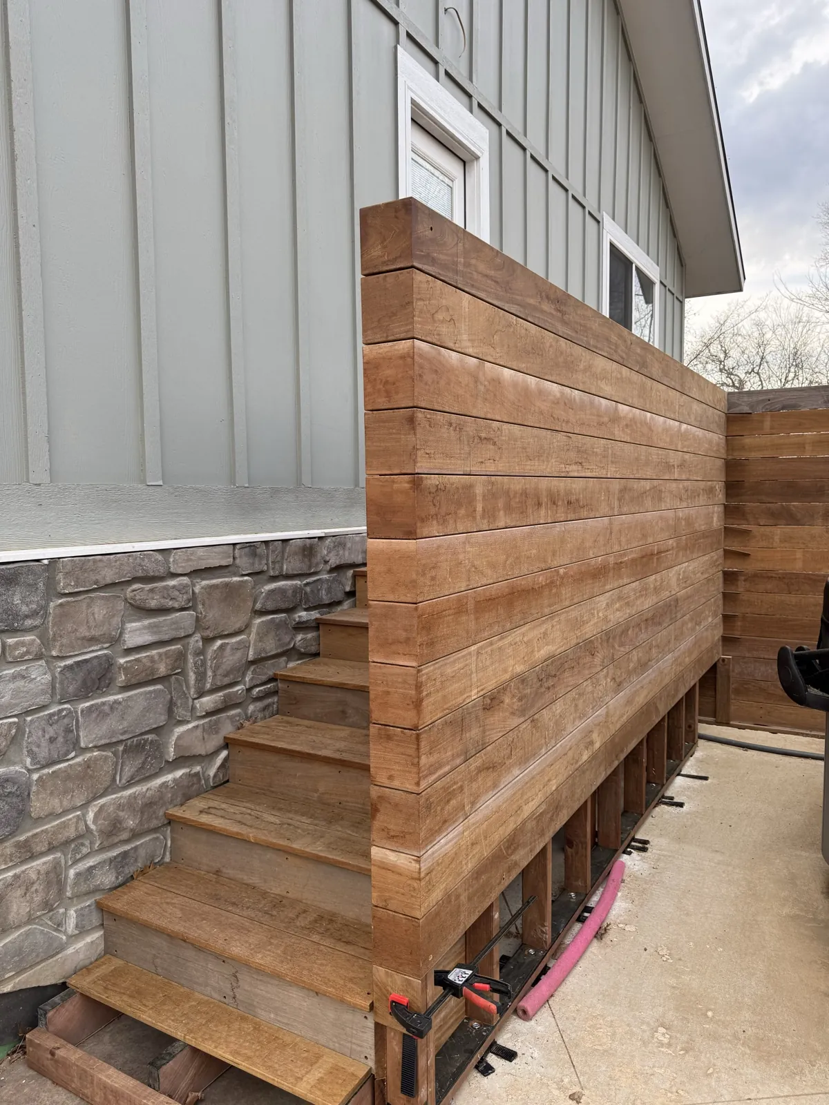 Curved ipe wall beside a pool with steps down