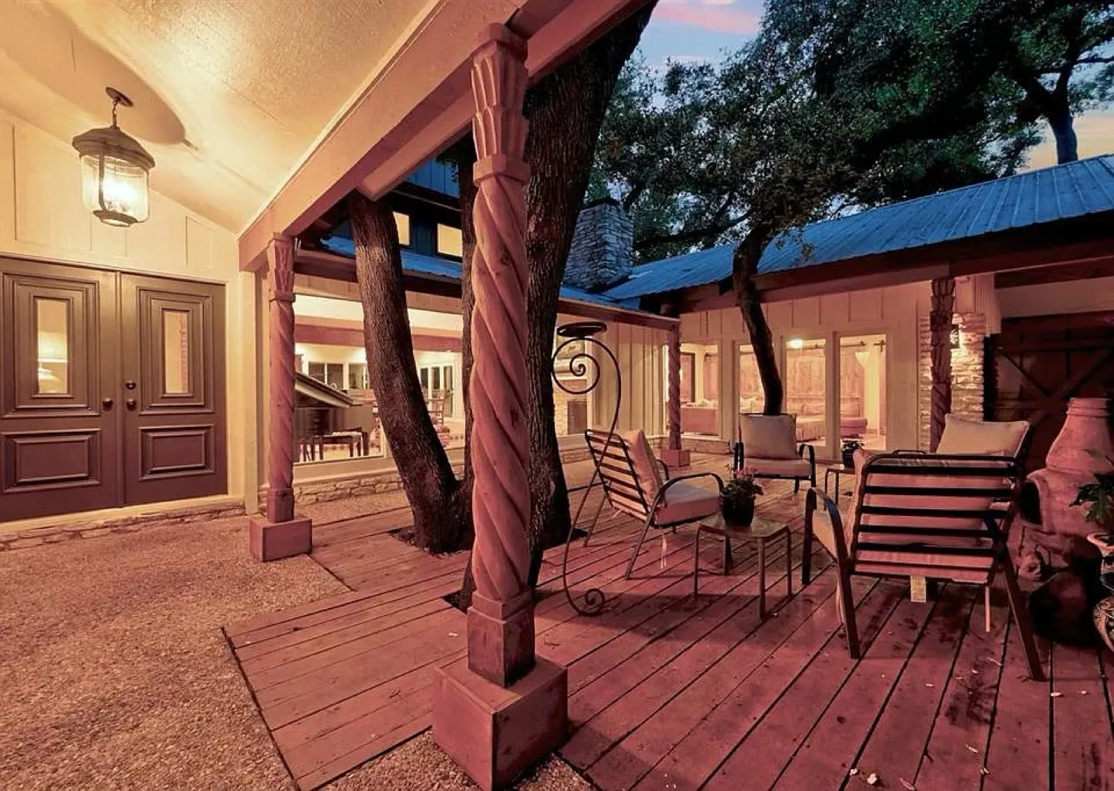 Covered deck with carved wood columns at twilight